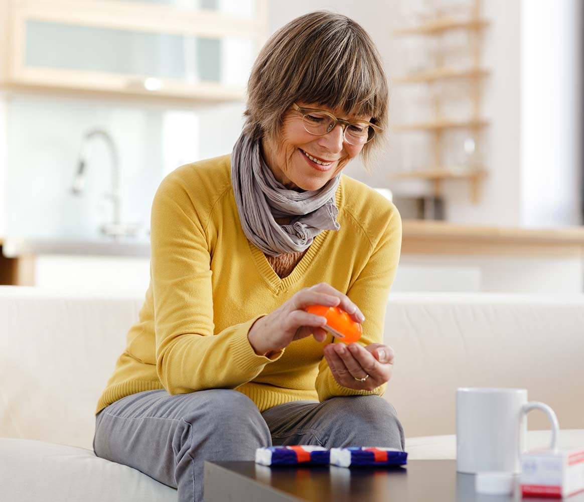 happy elderly woman taking prescription medication